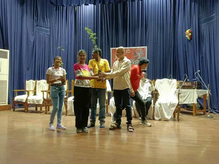 A young volunteer receiving a sapling at the plantation drive